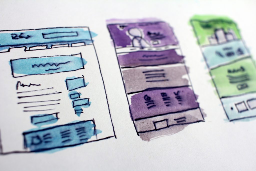 Website wireframe sketches on note paper.