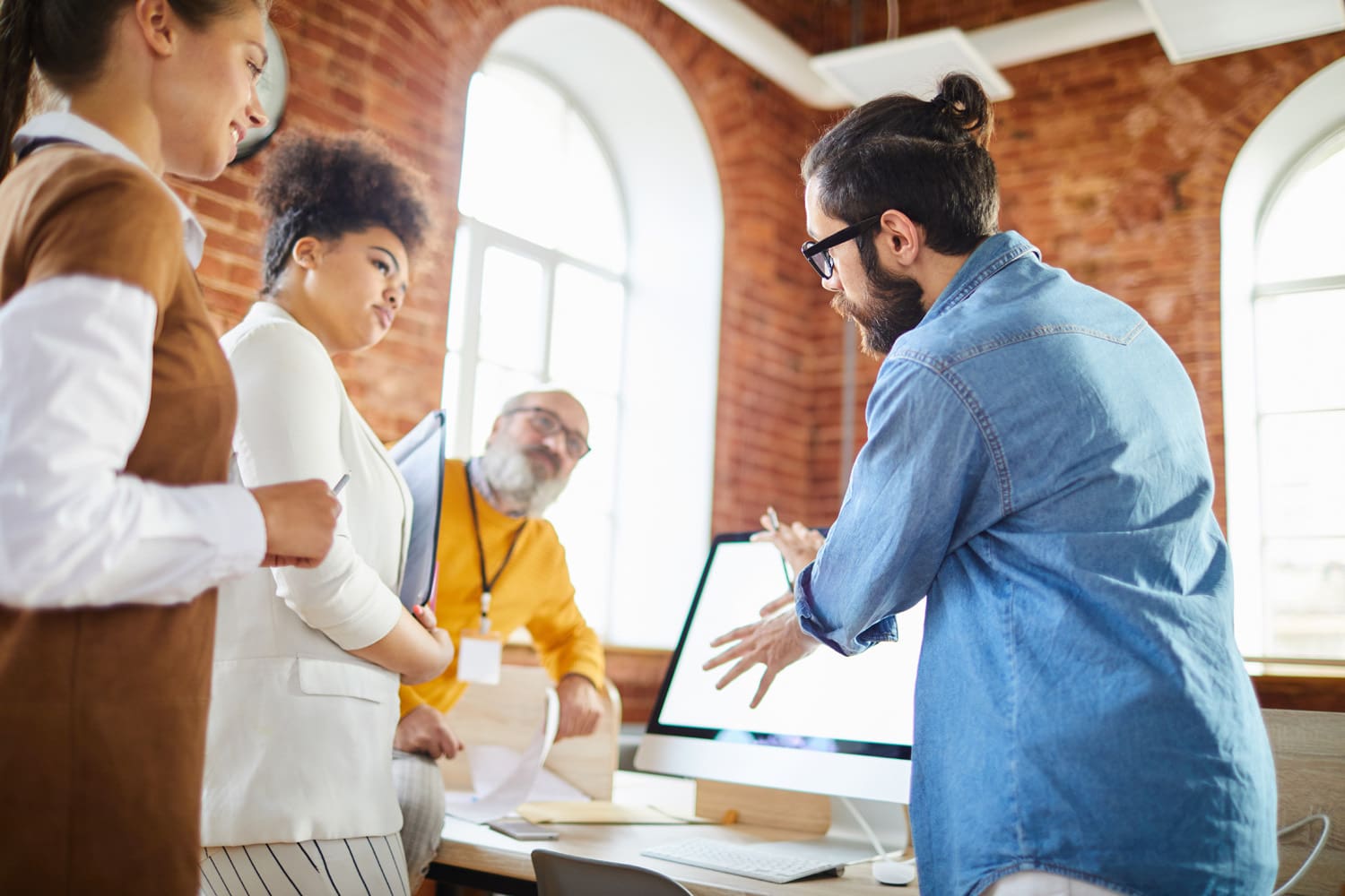 Three colleagues listening to office manager idea or explanation of working moments at meeting