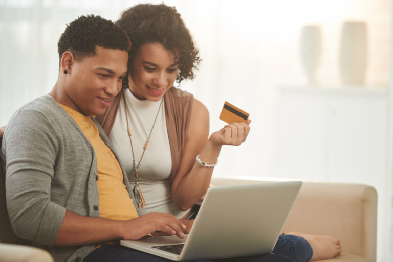 smiling couple shopping online at home